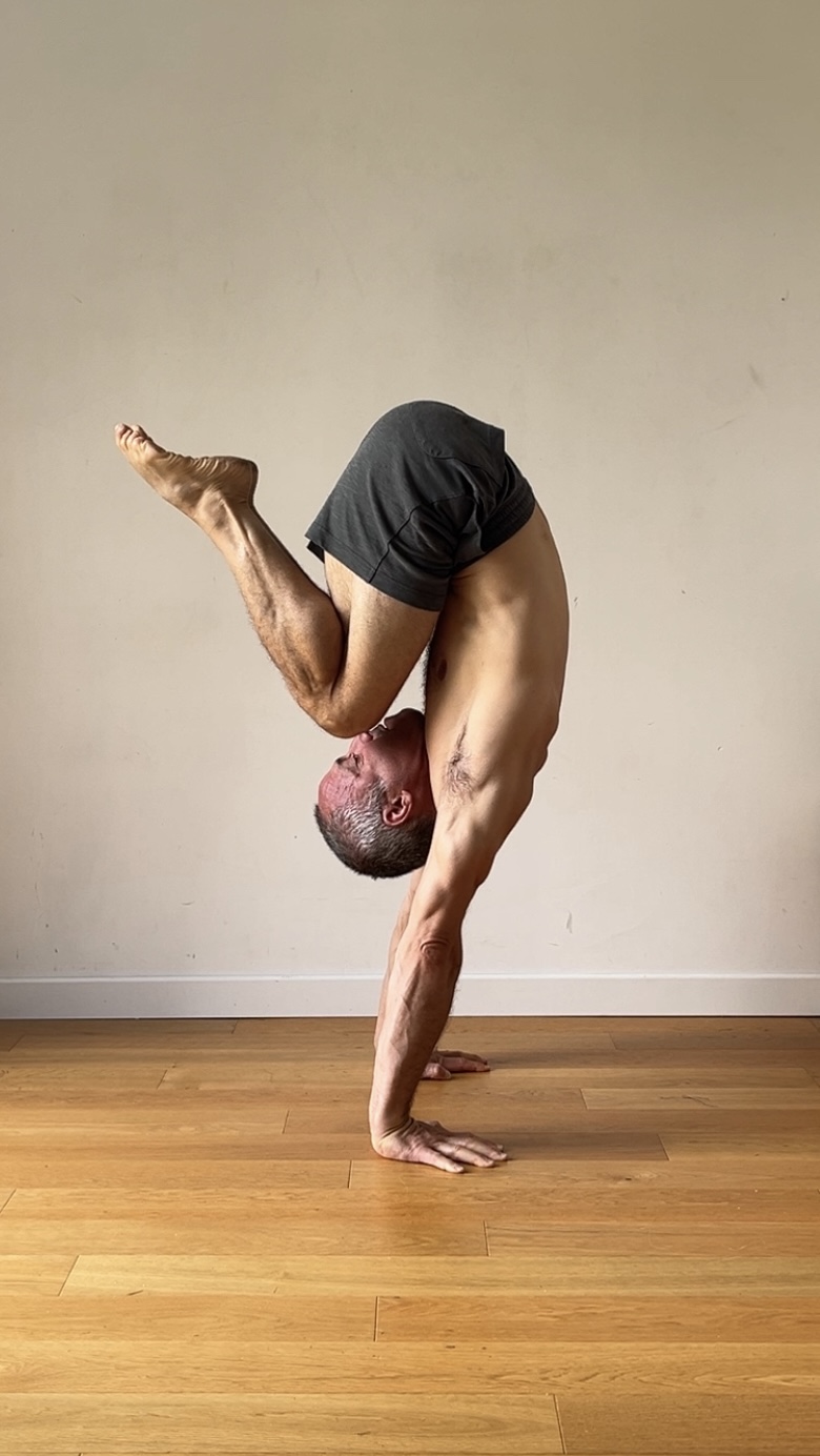 One-arm handstand on wooden floor