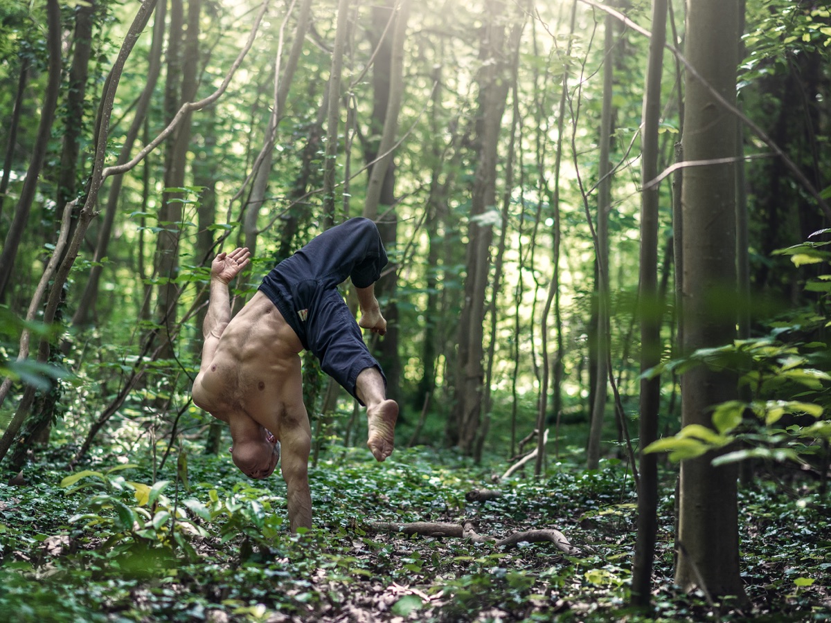Artistic handstand in green forest